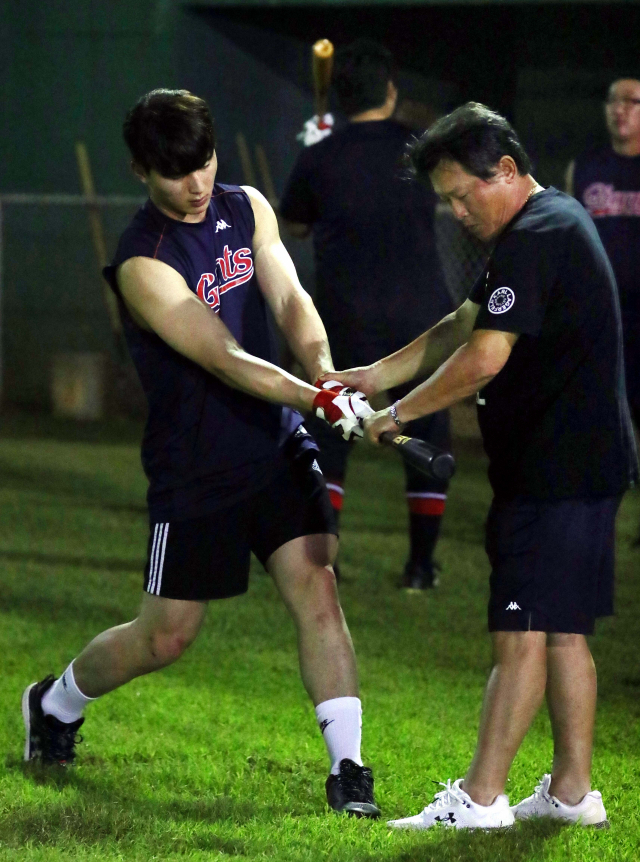 롯데 외야수 윤동희가 지난 2월 괌에서 열린 롯데 자이언츠 스프링캠프에서 '타격 코칭의 신' 박흥식 롯데 1군 수석코치 겸 타격코치로부터 타격 스윙을 교정받고 있다. 정종회 기자 jjh@