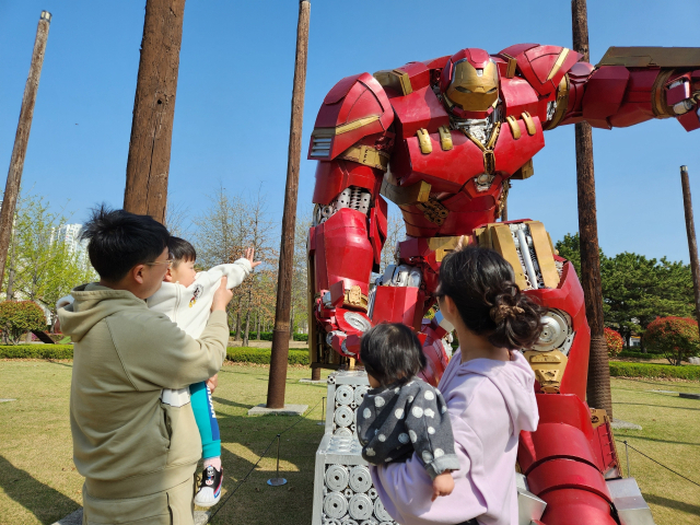 부산시민공원 기억의 기둥 일대에 설치된 로봇 작품을 한 가족이 보고 있다. 부산시설공단 제공