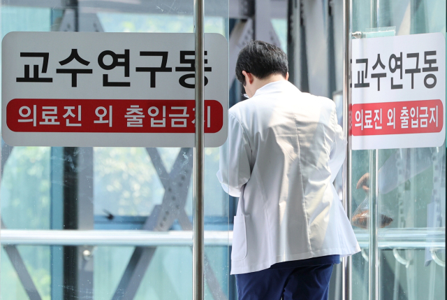 전국의과대학교수협의가 휴진 동참을 결의한 13일 서울의 한 대학병원에서 의료 관계자가 이동하고 있다. 연합뉴스