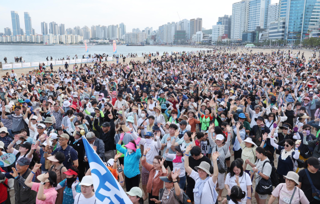 지난 16일 오후 부산 수영구 광안리해수욕장에서 세븐비치 어싱 챌린지 두 번째 행사 참가자 4000여 명이 출발에 앞서 다 함께 몸풀기를 하고 있다. 정종회 기자 jhyun@