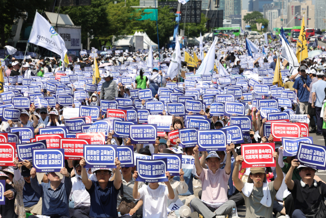 대한의사협회(의협)의 주도로 개원의와 일부 의대 교수들이 집단휴진에 나선 18일 오후 서울 영등포구 여의대로에서 열린 전국 의사 총궐기대회에서 참가자들이 팻말을 들고 있다. 연합뉴스