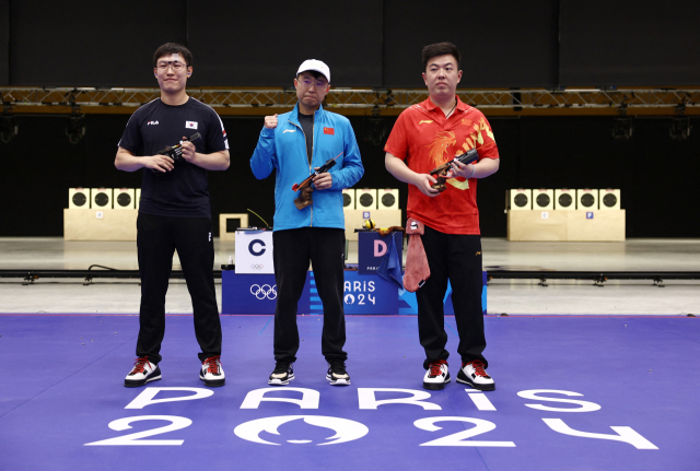 25m 속사권총 남자 결승에서 2위를 차지한 조영재(왼쪽)가 1위 리웨훙(가운데), 3위 왕쉰제와 기념 사진을 찍고 있다. AP연합뉴스