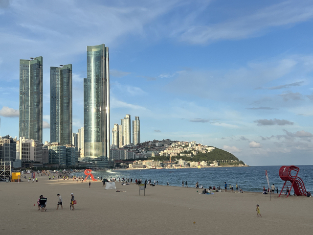 18일 부산 해운대 해수욕장에서 보이는 엘시티와 달맞이고개 아파트. 늦은 오후 피서를 위해 해수욕장을 찾은 시민들이 이들 아파트를 배경으로 해수욕을 즐기고 있다. 이현정 기자