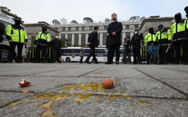 20일 서울 종로구 헌법재판소 앞에 보수단체 회원이 기자회견을 하던 더불어민주당 원내부대표단에게 던진 계란이 계란이 떨어져 있다. 연합뉴스