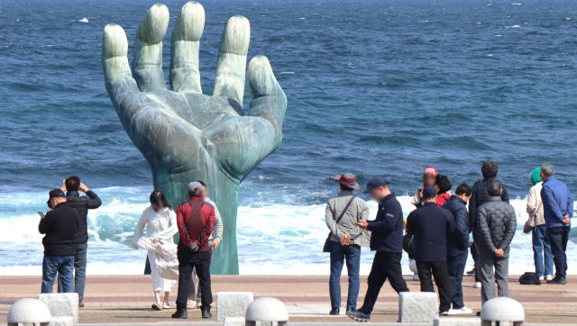 경북 포항시 호미곶을 찾은 관광객들이 ‘상생의 손’을 배경으로 사진을 찍고 있다. 남태우 기자