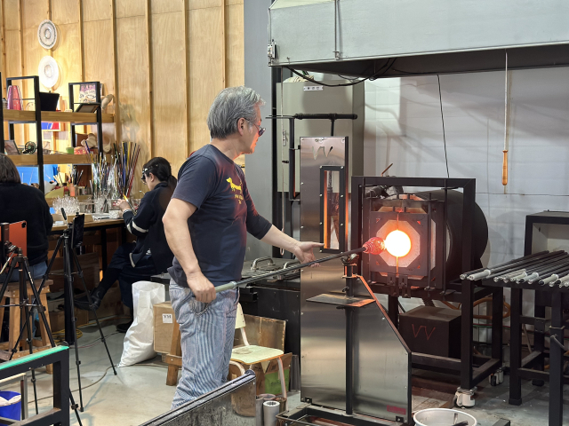 '유리: 빛과 불의 연금술' 작가 워크숍 중 카쿠라이 히데아키(KAKURAI HIDEAKI) 작가의 블로잉. 클레이아크김해미술관 제공