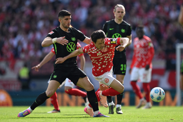 독일 프로축구 분데스리가 마인츠의 이재성(가운데)이 19일(현지 시간) 독일 마인츠의 메바 아레나에서 열린 볼프스부르크와의 2024-2025 분데스리가 30라운드 홈 경기에서 상대 선수와 볼 경합을 벌이다 넘어지고 있다. AFP연합뉴스