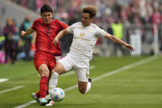 바이에른 뮌헨의 김민재(왼쪽)가 26일(현지 사간) 독일 뮌헨의 알리안츠 아레나에서 열린 마인츠와의 2024-2025 분데스리가 31라운드 홈 경기에서 상대 선수와 공 다툼을 벌이고 있다. AP연합뉴스