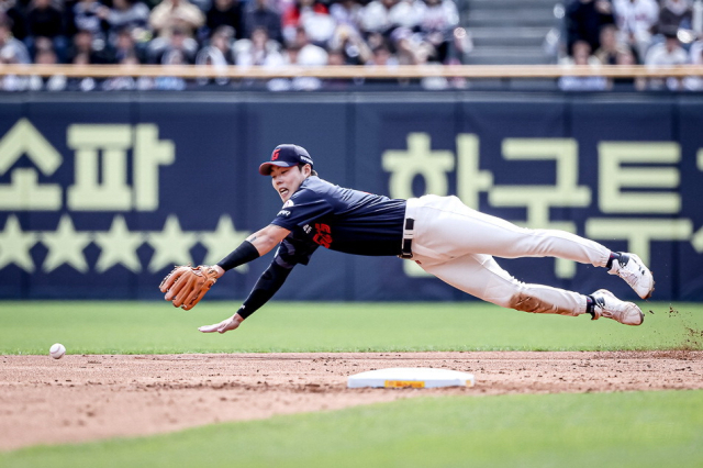 롯데 자이언츠 박진이 27일 서울에서 열린 2025 프로야구 두산 베어스전에서 힘차게 공을 던지고 있다(위). 롯데 2루수 고승민이 몸을 던져 공을 잡아내고 있다. 롯데 자이언츠 제공