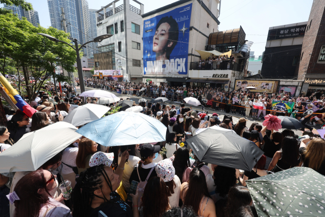 방탄소년단(BTS) 멤버 지민과 정국의 전역일인 지난 11일 서울 용산구 하이브 사옥 앞에서 국내외 아미(ARMY·BTS의 팬덤)들이 제대를 축하하고 있다. 연합뉴스