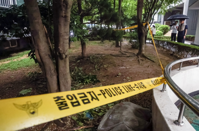 지난 21일 오전 부산 해운대구의 한 아파트 화단에서 고교생 3명이 숨진 채 발견됐다. 폴리스라인이 설치된 아파트 화단. 김종진 기자 kjj1761@