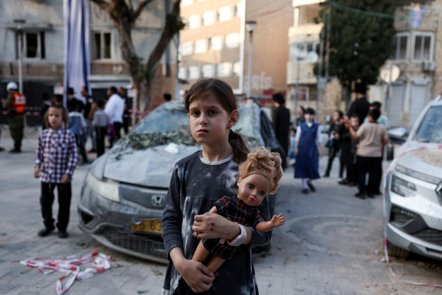 이스라엘 한 소녀가 22일(현지 시간) 이란의 공습을 받은 이스라엘 하이파 지역에서 인형을 들고 있다. 로이터연합뉴스