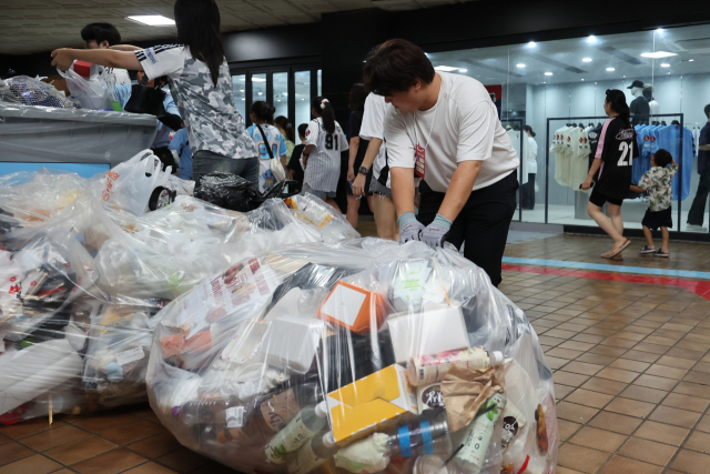 지난달 29일 오후 10시 부산 사직야구장 쓰레기통 주변에 쓰레기가 쌓여있는 모습(위)과 분리수거에 참여한 <부산일보> 김재량 기자. 롯데자이언츠 제공