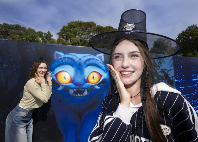 에버랜드가 넷플릭스 애니메이션 영화 '케이팝 데몬 헌터스' 테마존을 오는 9월 26일 오픈한다. 모델들이 '케이팝 데몬 헌터스' 테마존을 배경으로 에버랜드와 넷플릭스가 협업한 한정판 굿즈를 들고 포즈를 취하고 있다. 연합뉴스