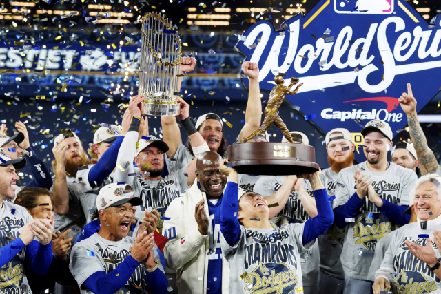 LA 다저스 투수 야마모토 요시노부가 2일(한국 시간) 캐나다 토론토에서 벌어진 2025 미프로야구 메이저리그 월드시리즈 7차전에서 이겨 대회 2연패를 달성한 뒤 데이브 로버츠 감독과 동료 선수들의 박수 속에 우승 트로피를 높이 든 채 환호하고 있다. AP연합뉴스