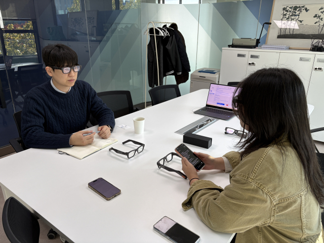 지난달 27일 부산대학교 본관 2층 미래정책실에서 <부산일보> 취재진(왼쪽)이 ‘AI 통번역 안경’을 쓴 채 한혜진(오른쪽) 전임연구원의 중국어 인사말을 듣고 있다. 이상배 기자 sangbae@