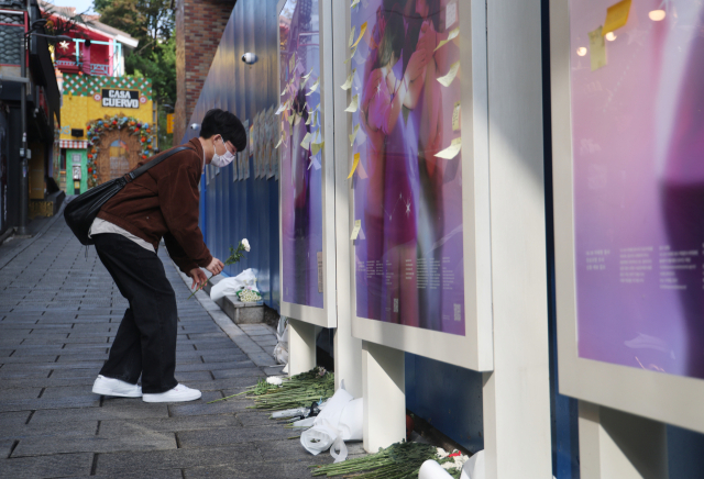 이태원 참사 3주기를 맞아 실시한 설문조사에서 국민 3명 중 2명은 “한국이 더 안전해지지 않았다”고 느낀다는 결과가 나왔다. 사진은 이태원 참사 3주기인 지난달 29일 참사 현장에서 한 시민이 헌화를 하는 모습. 연합뉴스