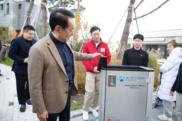 지난 16일 강서구 호반써밋 스마트시티 아파트에서 김도읍 의원이 짐캐리(배송) 로봇을 살펴보는 모습. 부산시 제공