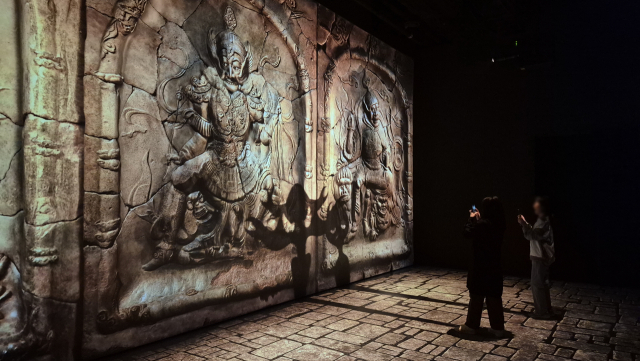 관람객들이 경북 경주시 ‘플래시백 계림’의 ‘수호자’에서 도깨비 모양 그림자를 보며 사진을 찍고 있다. 남태우 기자