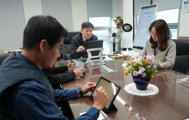 한국해양교통안전공단(KOMSA) 김준석 공단 이사장(가운데)이 집무실에서 기획조정실 직원들과 대형 모니터와 태블릿PC를 활용한 ‘종이 없는 회의’를 진행 중인 모습. KOMSA 제공