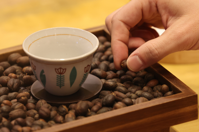 고환율 여파로 커피나 소고기, 과일, 밀과 같은 주요 수입 식품의 물가가 줄줄이 치솟고 있다. 지난달 19일 서울 강남구 코엑스에서 열린 제24회 서울카페쇼에서 한 관람객이 커피 시음 전 원두를 만져보고 있다. 연합뉴스