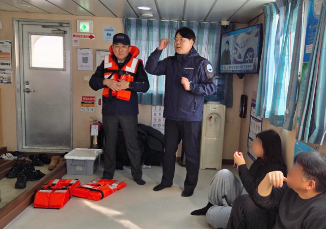 김준석 한국해양교통안전공단(KOMSA) 이사장(왼쪽)이 지난 3일 군산~개야도를 운항하는 국가보조항로 여객선 ‘개야카훼리호’에서 승선객을 대상으로 구명조끼 착용법을 직접 시연하고 있다. KOMSA 제공