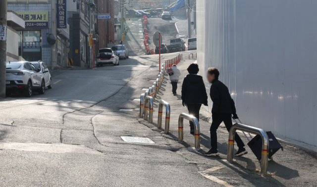 부산 남구 대연중학교의 정·후문 일대 재개발 공사로 학생 통학 안전이 우려되고 있다. 지난 5일 오후 재개발 공사 현장 좁은 통행로로 시민들이 지나가고 있다. 정종회 기자 jjh@