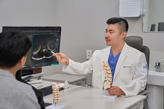 척추 압박골절 환자는 골다공증 치료를 반드시 병행해야 재골절 위험을 줄일 수 있다. 환자와 상담 중인 명지오션척병원 박도영 병원장. 명지오션척병원 제공
