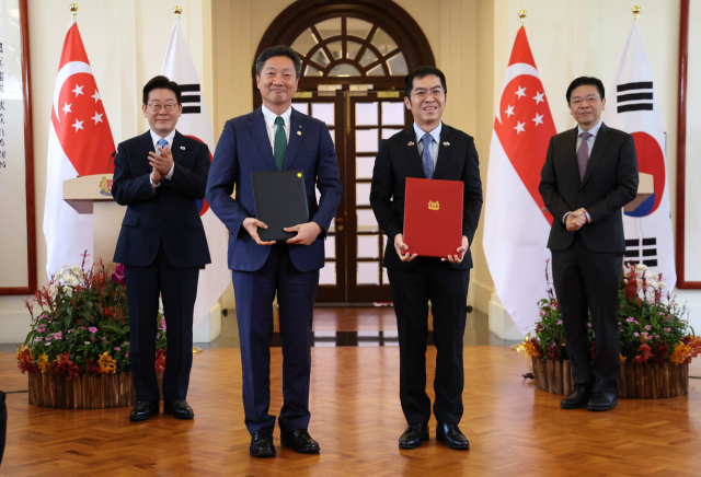 전대욱 한국수력원자력 사장 직무대행과 푸아 켁 켱 싱가포르 에너지시장청장이 2일 싱가포르 외교부 청사에서 이재명 대통령과 로런스 웡 싱가포르 총리가 참석한 가운데 소형모듈원자로(SMR) 협력에 관한 MOU를 체결한 뒤 기념촬영을 하고 있다. 연합뉴스