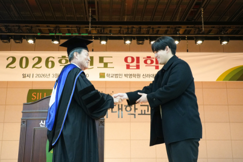 신입생 선서자 대표컴퓨터교육과 이재동 학생과 악수하는 허남식 총장.