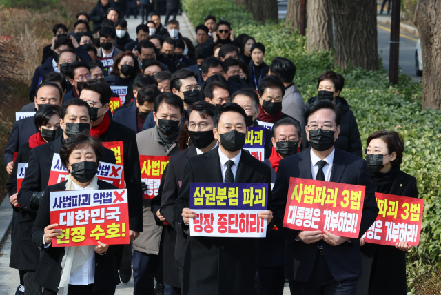 장동혁 대표와 송언석 원내대표를 비롯한 국민의힘 의원들이 5일 청와대 분수대 앞에서 의원총회를 마친 뒤 손팻말을 들고 청와대 방향으로 이동하고 있다. 연합뉴스