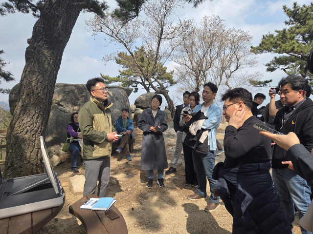 금정산국립공원 전망대에서 국립공원공단 문창규 자원보전과장이 기후에너지환경부 기자단에게 ‘금정산국립공원 현황 및 관리계획’을 보고하고 있다. 공동취재단
