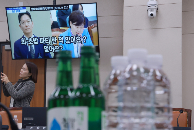 8일 국회에서 열린 법제사법위원회 전체회의에서 위원장인 더불어민주당 서영교 의원이 준비한 박상용 검사의 입법 청문회 질의 영상이 디스플레이에 나오고 있다. 오른쪽은 민주당 전현희 의원이 질의를 위해 준비한 소주와 생수. 연합뉴스