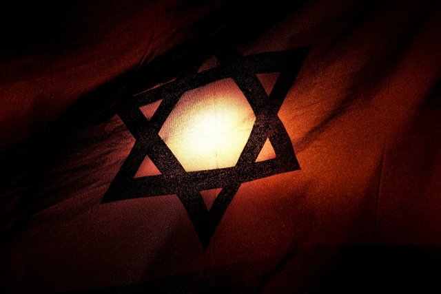 23일(현지 시간) 이스라엘 텔 아비브에서 이스라엘 국기 너머로 석양이 지고 있다. 로이터 연합뉴스