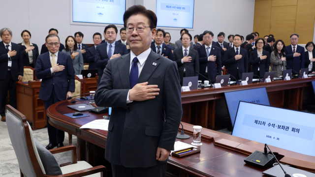 이재명 대통령이 30일 청와대에서 열린 수석보좌관회의에서 국기에 경례하고 있다. 연합뉴스