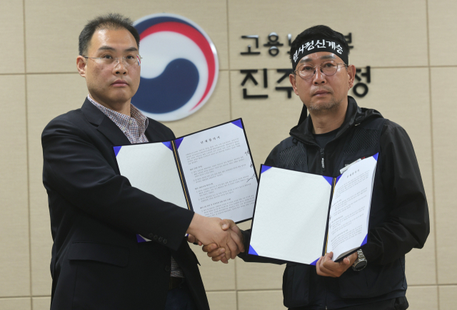 이민재(왼쪽) BGF로지스 대표이사와 김동국 화물연대 위원장이 30일 경남 진주시 고용노동부 진주지청에서 단체합의서 조인식을 가진 뒤 기념 촬영을 하고 있다. 연합뉴스