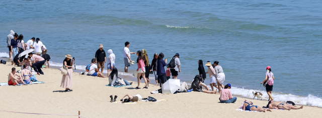 전국적으로 초여름 날씨를 보인 13일 오후 부산 해운대해수욕장을 찾은 외국인들이 해수욕과 태닝을 즐기고 있다. 김종진 기자 kjj1761@
