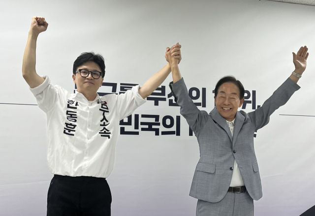 김영삼(YS) 전 대통령 차남인 김현철 김영삼 대통령기념재단 이사장(오른쪽)이 23일 오후 부산 북갑 국회의원 보궐선거에 출마한 무소속 한동훈 후보(왼쪽) 선거캠프에서 지지를 선언하는 기자회견을 한 뒤 만세하고 있다. 연합뉴스