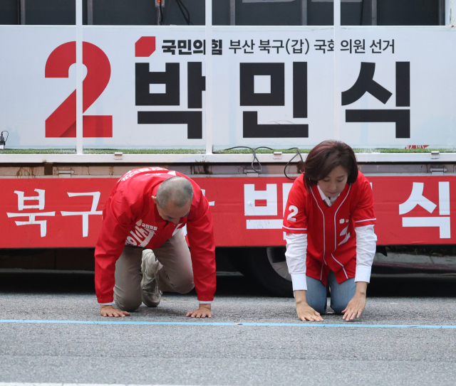 국민의힘 박민식 부산 북갑 국회의원 보궐선거 후보가 23일 오후 부산 북구 도시철도 덕천역 부근에서 지원유세를 온 나경원 의원과 아스팔트 위에서 큰절을 하고 있다. 연합뉴스