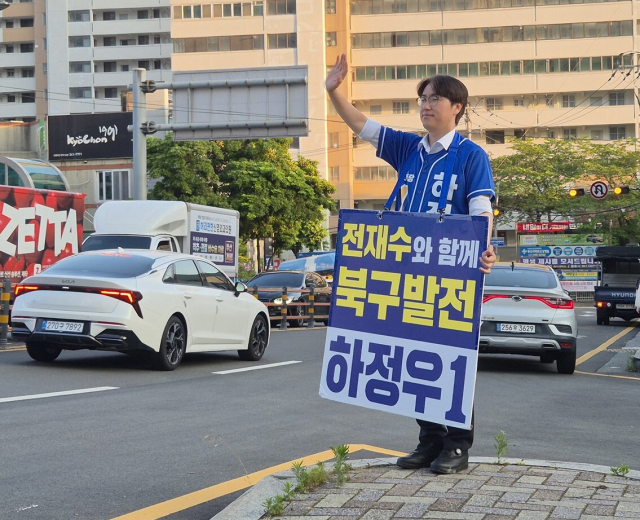 부산 북갑 보궐선거 더불어민주당 하정우 후보가 지난 29일 만덕역 일대에서 차량에 탄 주민들에게 인사를 하고 있다. 이우영 기자