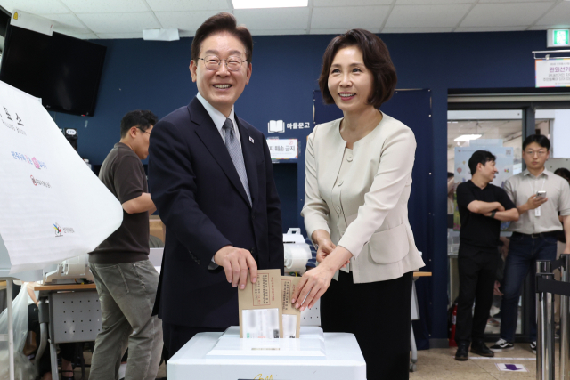 이재명 대통령과 김혜경 여사가 지방선거 사전투표 첫날인 지난달 29일 서울 종로구 삼청동 주민센터에 마련된 사전투표소에서 투표용지를 투표함에 넣고 있다. 연합뉴스