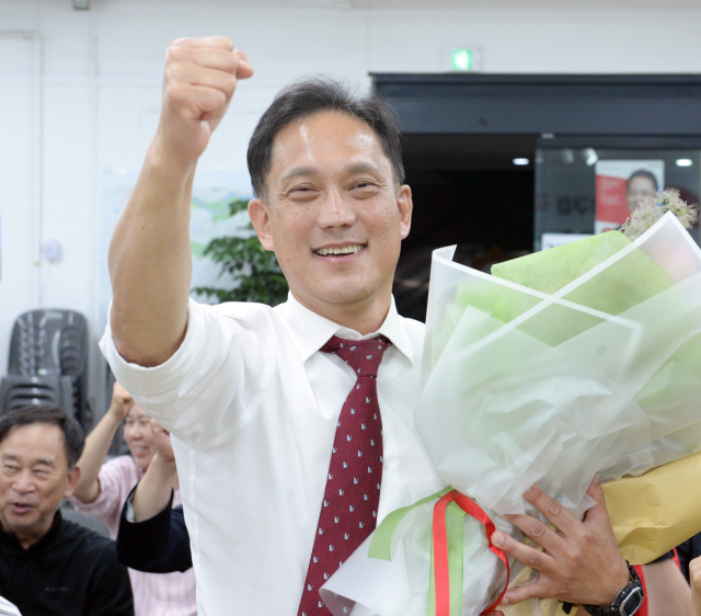 국민의힘 김태규 울산 남구갑 국회의원 후보가 4일 자신의 선거사무소에서 당선이 확실시되자 꽃다발을 받고 환호하고 있다. 연합뉴스