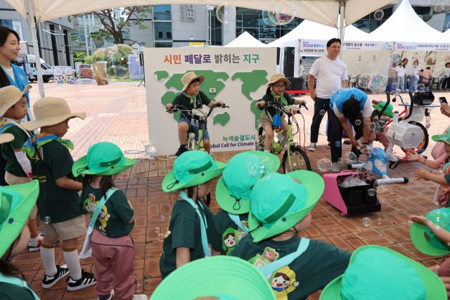 양산시는 지난 5일 제31회 환경의 날을 맞아 양산문화예술회관 광장에서 다양한 환경체험부스를 운영해 좋은 반응을 얻었다. 이날 어린이들이 자전거 발전기를 이용해 전기를 생산하는 ‘시민 페달로 밝히는 지구’ 프로그램에 참가해 즐거운 시간을 보내고 있다. 김태권 기자
