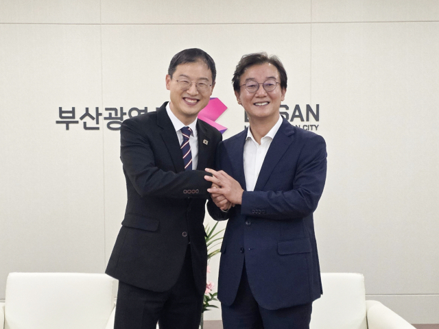 김상욱 울산시장(왼쪽)과 전재수 부산시장이 2일 부산시청에서 만나 손을 맞잡고 기념사진을 촬영했다. 두 단체장은 이날 광역 대중교통 노선 개선과 해변 마라톤 공동 개최 등 시도 간 다양한 협력 방안을 논의했다. 울산시 제공