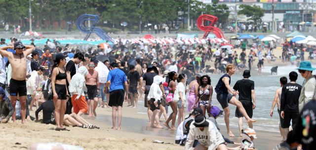 부산을 비롯한 전국 대부분 지역에 폭염 경보가 발효된 12일 오후 부산 해운대해수욕장에서 외국인 관광객 등 많은 피서객들이 물놀이를 하며 더위를 식히고 있다. 정종회 기자 jjh@