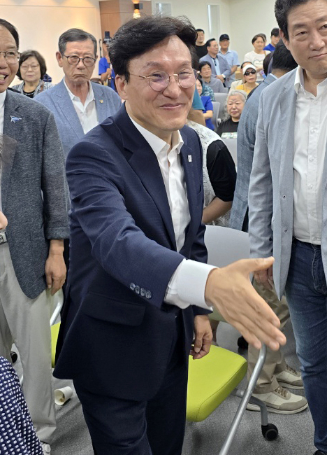 더불어민주당 당권주자인 김민석 전 국무총리가 19일 오후 민주당 부산시당에서 열린 부산 권리당원 간담회에서 참석자들과 인사하고 있다. 연합뉴스
