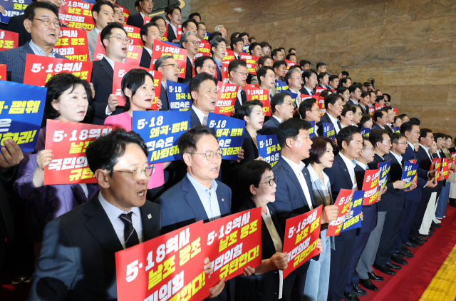 더불어민주당 한병도 당 대표 직무대행 겸 원내대표와 참석 의원들이 13일 국회 로텐더홀 계단에서 열린 '민생입법 방해·5.18 역사 왜곡 국민의힘 규탄대회'에서 손팻말을 들고 구호를 외치고 있다. 연합뉴스