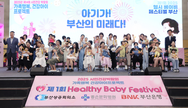 지난해 부산 해운대 벡스코에서 열린 ‘제1회 헬시 베이비 페스티벌‘에서 큐티 베이비 선발대회 본선에 오른 아기와 부모들이 기념사진을 찍고 있다. 부산일보DB