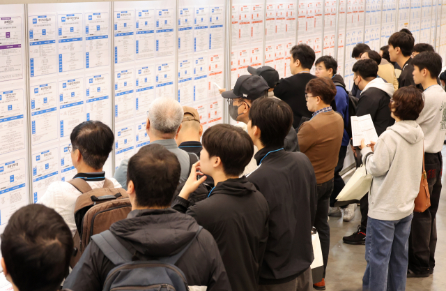 지난 26일 부산 해운대구 벡스코에서 열린 '2026 KB굿잡 부산 잡(JOB) 페스티벌'에서 구직자들이 채용공고 게시판을 살펴보고 있다. 이번 행사에는 부산 지역 우수기업 등 220여 개 기업이 참가했다. 연합뉴스